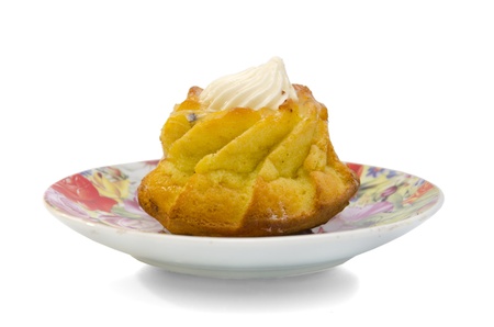 Cupcake with swirls of creamy frosting on a plate on a white backgroundの写真素材