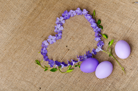 Blue flowers in a shape of a heart with Easter eggs
