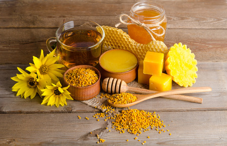Still life of cup of tea,  honey, honeycombs, wax and pollen granule on wooden backgroundの写真素材
