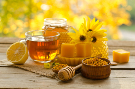 Still life from cup of tea , lemon, honey, wax , honeycombs and pollen granule on wooden table