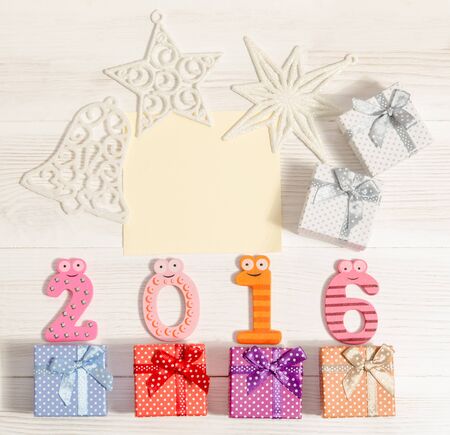 composition from numbers 2016 and gift boxes on wooden table