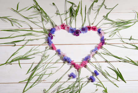 Beautiful cornflowers in shape of heart on wooden backgroundの写真素材