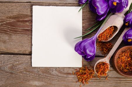 crocus flowers with empty card for your text with soffron on wooden background