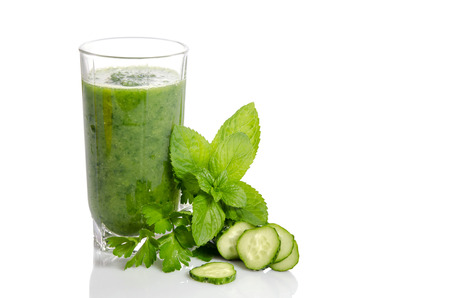 Green smoothie with cucumber, mint and parsley as healthy summer drink isolated on whiteの写真素材