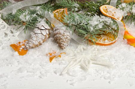 Greeting card for Christmas with pine cone and dried oranges on wooden topの写真素材