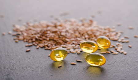 Flaxseed oil in caps on a grey background. Phytotherapy. の写真素材