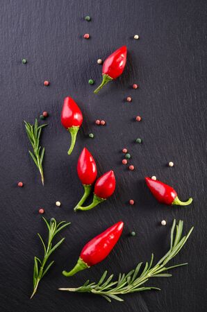 Chili peppers with rosemary on a black backgroundの写真素材