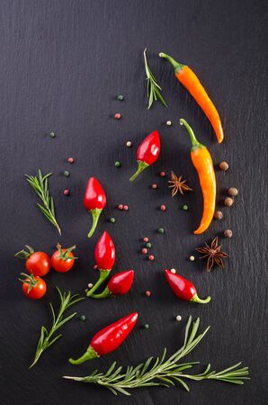 Different spices with tomato and  peppers on a black backgroundの写真素材