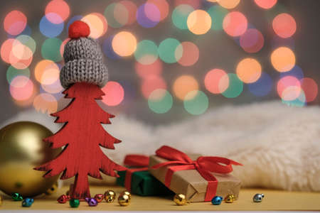Red Christmas tree in a hat, gifts, balls and bokeh New Year decoration.の写真素材