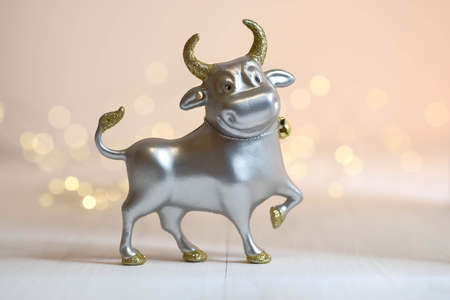 A silver bull stands on a white table. Christmas decorationsの写真素材