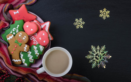 Gingerbread cookies in a bowl, cocoa in a cup and snowflakes on a black top. Christmas decoration.の写真素材