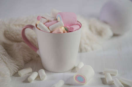 Tall cup with multi-colored marshmallows and white balls on the table. Christmas decorationsの写真素材