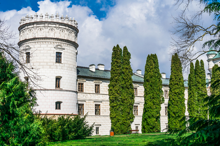 The castle tower houses surrounded by seasonal plants and part of the yard and sidewalk with benchのeditorial素材