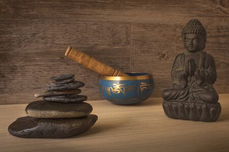 buddha figure, tibetan bowl and stacked stonesの写真素材