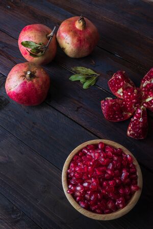 three pomegranate with bowl on real wooden table wonderful colorsの写真素材
