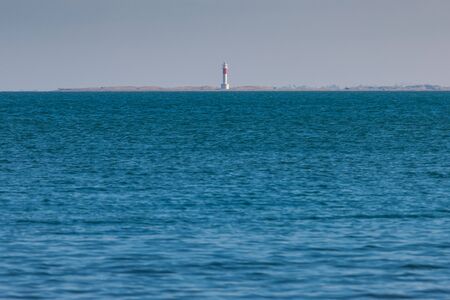 lighthouse in the middle of the sea blue tones