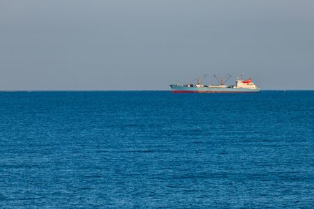 freight ship sailing on the horizon blue tonesの写真素材