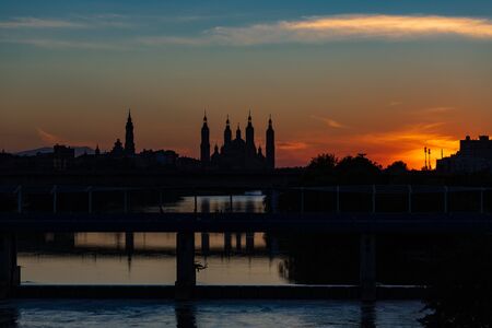 sunset in Zaragoza with seo cathedral and pilar cathedral in the background and a plane taking off....