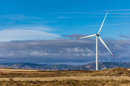 wind turbine in the foreground with many wind turbines on the horizonの写真素材