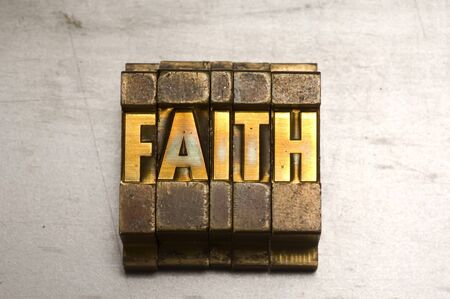 Brass / Gold colored letterpress piece on silver metal backgroundの写真素材