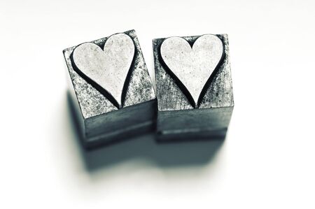 Image of 2 vintage Letterpress Heart characters, narrow focus, cross processed.