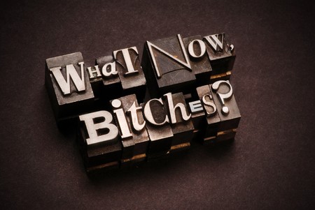 The phrase What Now, Bitches? photographed using vintage letterpress type with shallow focus.の写真素材