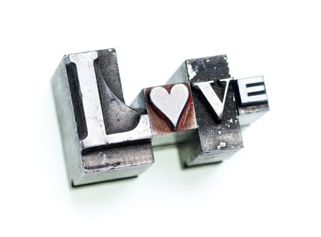 The word Love done with letterpress type and a heart character, shallow focus on heart, cross-processed.の写真素材