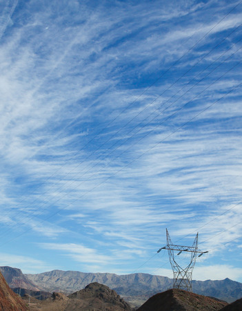 Nature vs progress. An electrical wire tower in desert with beautiful landskapeの写真素材