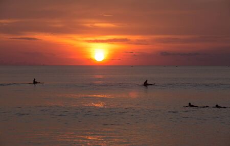 Surfers in the ocean at sunset. Chilling in waterの写真素材