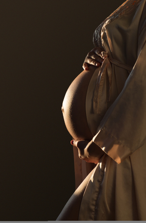 Beautifil Silhouette of a pregnant woman with highlight on belly copy spaceの写真素材