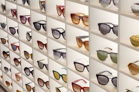 Various different sunglasses in the shop display shelvesの写真素材