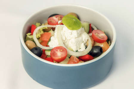 Greek salad with fresh vegetables feta cheese and black olives in bowlの写真素材