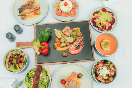 Fish and meat meals variety flat lay top view on dinner lunch buffetの写真素材