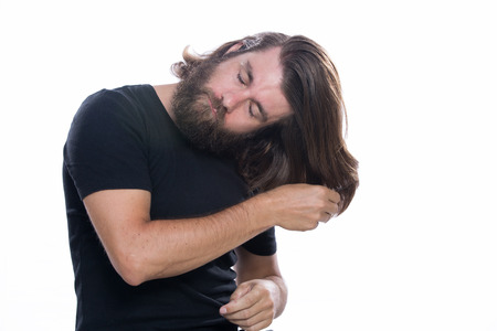 Man combs his hair with comb brush isolated on white backgroundの写真素材
