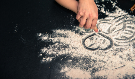 Happy loving family in the kitchen. Mother and child preparing the dough, bake cookiesの写真素材