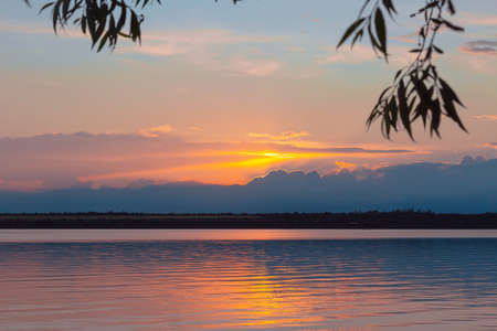 colored sunset over the river, with sky reflectionの写真素材