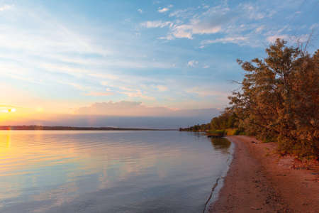 colored sunset over the river, with sky reflectionの写真素材