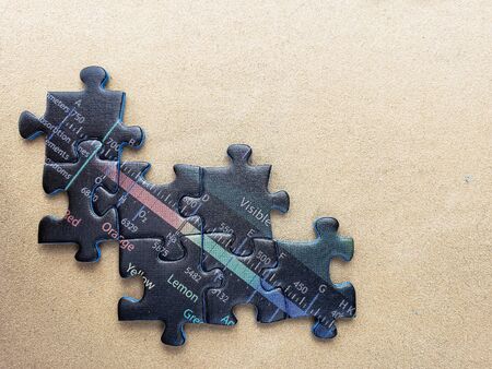 pieces of an incomplete puzzle jigsaw on a brown background
