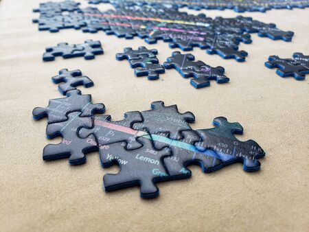 pieces of an incomplete puzzle jigsaw on a brown backgroundの写真素材