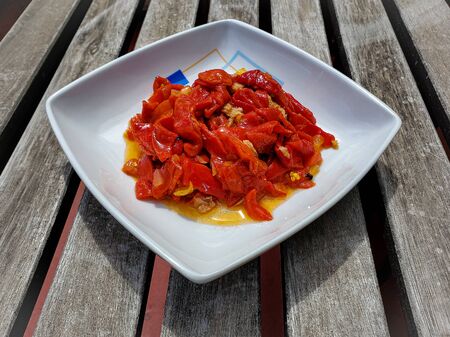 Red peppers salad with tuna and olive oil sauce in a white bowlの写真素材