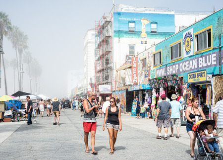 Shoppers walking along Venice Beach boardwalk on a misty morning with building construction in the backgroundのeditorial素材