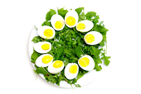 Boiled eggs on arugula over white background