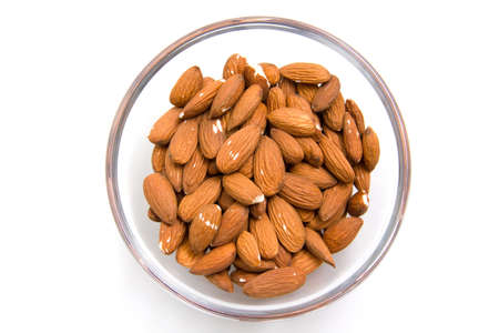 Almonds in a glass bowl on white background from aboveの写真素材