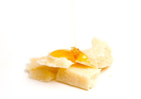 Cheese with pouring honey on white backgroundの写真素材