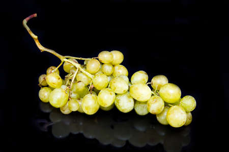 Bunch of grapes reflected on black background
