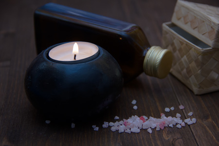 Candle with bath salts and oil on wooden tableの写真素材