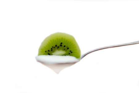 Yogurt with kiwi on spoon on white backgroundの写真素材