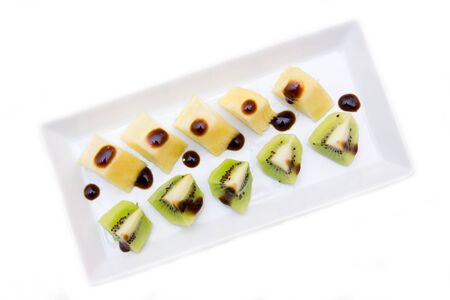 Pineapple and kiwi with balsamic vinegar on a white background seen from aboveの写真素材