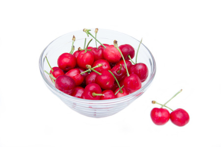 Cherries on bowl set on white background