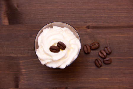 Glass with coffee and cream on wooden table seen from aboveの写真素材
